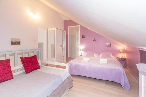 2 Betten in einem Zimmer mit lila Wänden in der Unterkunft Purple - Duplex cosy en plein cœur de l'Hermitage, proche du lagon in L'Ermitage-Les-Bains