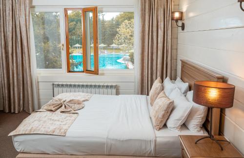 a bedroom with a bed with a view of a pool at RIVER INN RESORT AND SPA in Nabran