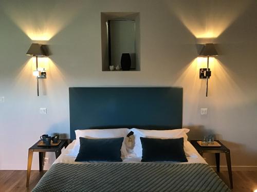 a bedroom with a bed with a blue headboard and two tables at La Grange Saint Martin in Fontaine-le-Port