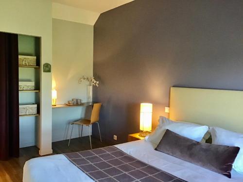 a bedroom with a bed and a table and a chair at La Grange Saint Martin in Fontaine-le-Port