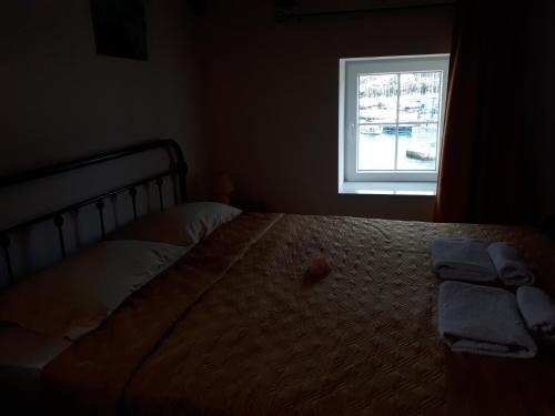 Bett in einem Schlafzimmer mit Fenster in der Unterkunft Guest House Provišta in Veli Iž