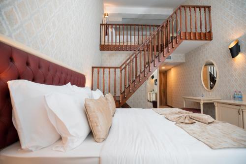 a bedroom with a large bed with a staircase at RIVER INN RESORT AND SPA in Nabran