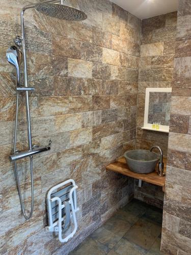 La salle de bains est pourvue d'un lavabo et d'une douche. dans l'établissement Hôtel le petit randonneur, à Cilaos