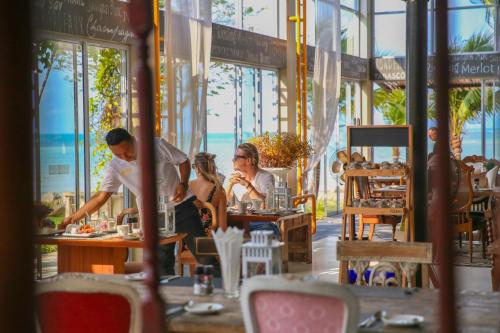 un groupe de personnes assises à des tables dans un restaurant dans l'établissement Summer Luxury Beach Resort & Spa, à Baan Tai