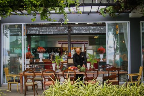 un homme debout devant un restaurant avec des tables et des chaises dans l'établissement Summer Luxury Beach Resort & Spa, à Baan Tai