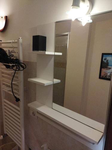 a bathroom with white shelves and a mirror at La Torre Monolocale in Padova