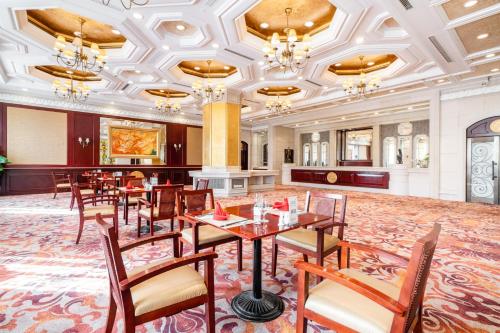 a restaurant with tables and chairs in a room at Maritim Hotel Taicang Garden in Taicang