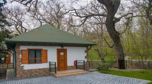 a small house with a porch and a tree at RIVER INN RESORT AND SPA in Nabran