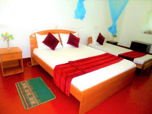 a bedroom with two beds and a red floor at Hotel White Sand Beach Nilaveli in Nilaveli