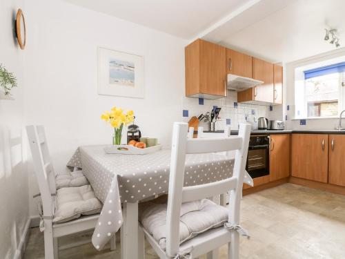 a kitchen with a table and chairs in a kitchen at Bell Cottage in Penzance