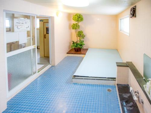 a room with a blue tiled floor in a room at Rusutsu Lodges Pension Lilla Huset in Rusutsu