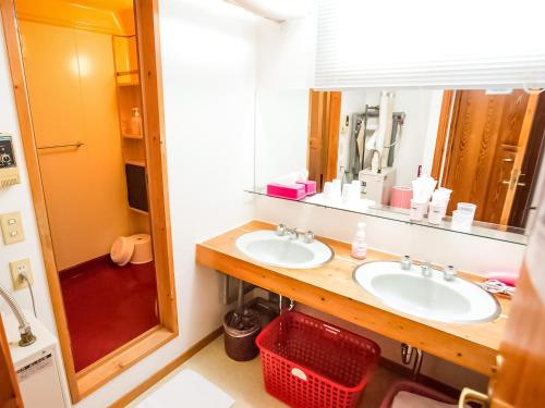 a bathroom with two sinks and a mirror at Rusutsu Lodges Pension Lilla Huset in Rusutsu