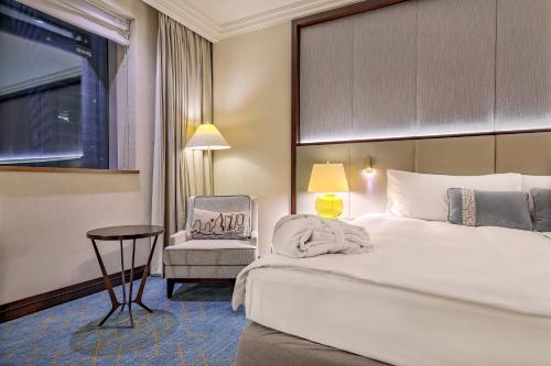 a hotel room with a bed and a chair at InterContinental Warszawa by IHG in Warsaw