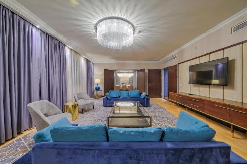 a living room with blue couches and a tv at InterContinental Warszawa by IHG in Warsaw