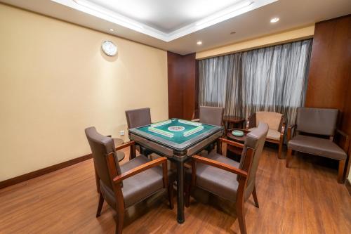a room with a poker table and chairs and a clock at Maritim Hotel Taicang Garden in Taicang