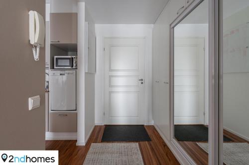 einen Flur mit einem Spiegel und eine Küche in der Unterkunft Homelike 1BR Apartment with Sauna, Balcony & Free Parking in Tampere