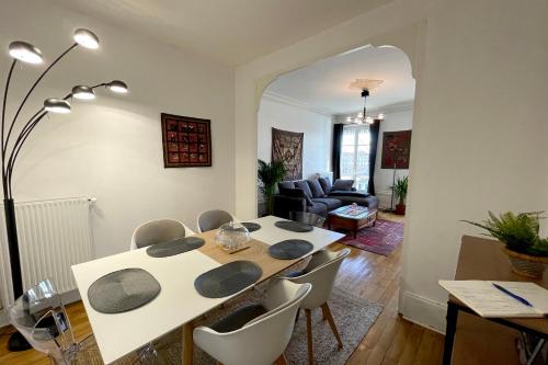 une salle à manger avec une table et des chaises blanches dans l'établissement PORTE DU VIEUX LYON, vue sur la saône, à Lyon