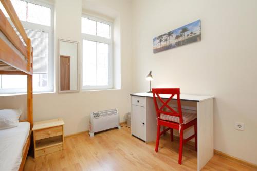 a bedroom with a desk and a red chair at Nomado Hostel in Varna City