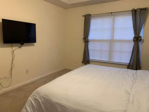 a bedroom with a bed and a flat screen tv at Lovely two-story house with spacious backyard in Summerville