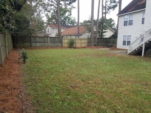 a yard with a fence and a house at Lovely two-story house with spacious backyard in Summerville