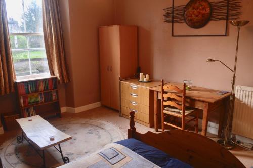 een slaapkamer met een bureau, een tafel en een bureau bij 250 yards from the Old Course and the town centre in St Andrews