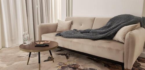 a couch with a blanket on it in a living room at ConnectIN Apartments in Pale