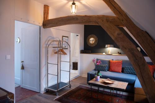 a living room with a blue couch and a ladder at La Maison Carpe Diem in Les Andelys