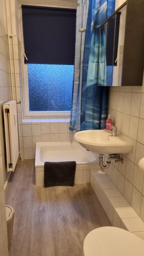 uma casa de banho com um lavatório, um WC e uma janela. em Stadtnah an der Förde 75 em Flensburg