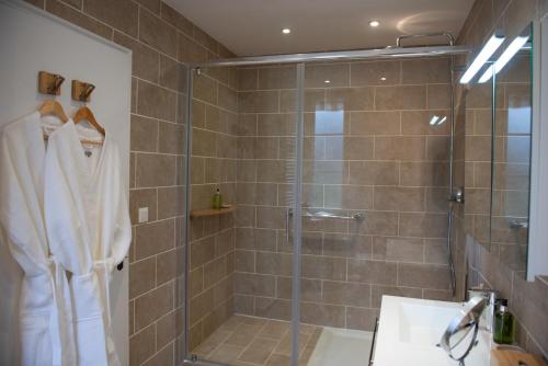 a bathroom with a shower with a glass door at La Maison Carpe Diem in Les Andelys