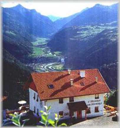 a house with a red roof on top of a mountain at Wirtshaus zum Wiesejaggl in Kaunerberg