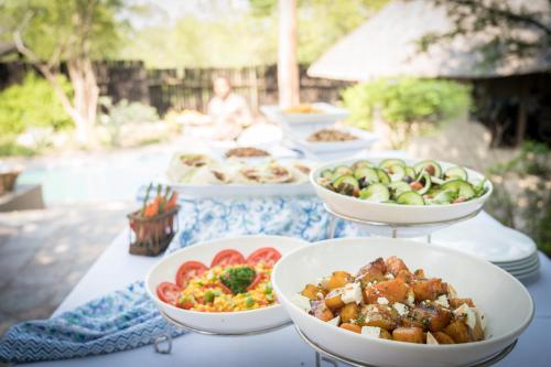 a table with several bowls of food on it at Kambaku Safari Lodge in Timbavati Game Reserve