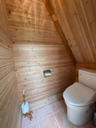 a bathroom with a toilet in a wooden room at Ecostay Glamping Rainbow Forest in Ishigaki Island