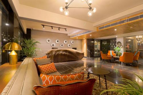 a lobby with a couch and a table and chairs at AIR by Ahuja Residences in Gurgaon