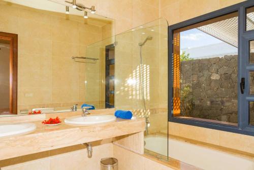 プラヤ・ブランカにあるArcのバスルーム(洗面台2台、ガラス張りのシャワー付)