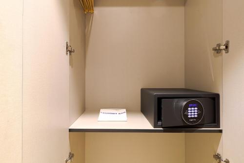 a microwave sitting on a shelf in a room at AIR by Ahuja Residences in Gurgaon