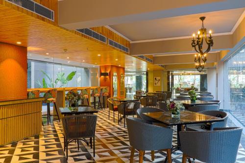 a restaurant with tables and chairs in a room at AIR by Ahuja Residences in Gurgaon