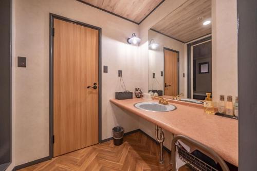 baño con lavabo y espejo grande en 飛騨高山 ホテル デリッシュ, en Takayama