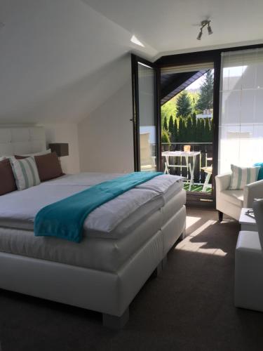 ein Schlafzimmer mit einem großen Bett und einem Balkon in der Unterkunft Gästehaus Cramer in Bad Kissingen