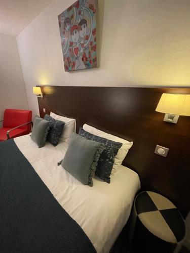a hotel room with a bed with two pillows at The Originals Boutique, Hôtel d'Angleterre, Le Havre, centre, plage in Le Havre