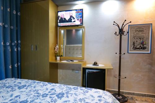 a bedroom with a bed and a tv on the wall at Hotel Lindi in Sarandë