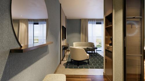 a living room with two chairs and a table at Hotel de Schelde in Cadzand-Bad
