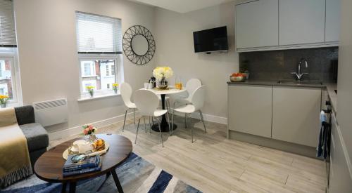 ein Wohnzimmer mit einer Küche und einem Tisch in der Unterkunft Aisiki Apartments at Stanhope Road, North Finchley, Airconditioned 3-Bedroom and 2-Bathroom, Pet-Friendly Duplex Flat, King or Twin Beds, with Free Wi-Fi in Finchley