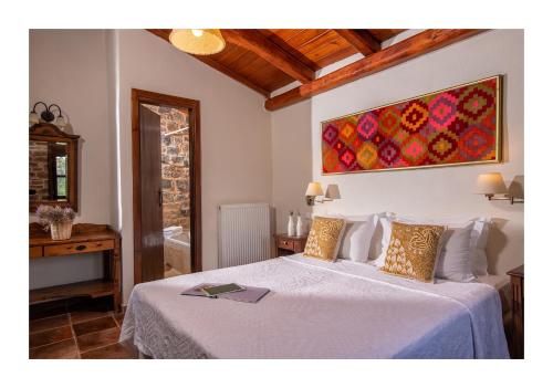 a bedroom with a bed and a painting on the wall at Enagron Ecotourism Village in Axós