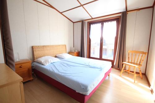 une chambre avec un lit, une chaise et une fenêtre dans l'établissement Spacieuse Maison d'angle dans domaine des TAMARIS 5 pièces 6 á 7 couchages WIFI- Accès payant pour piscines-animation - PORTIRAGNES PLAGE LRTAMJ37, à Portiragnes
