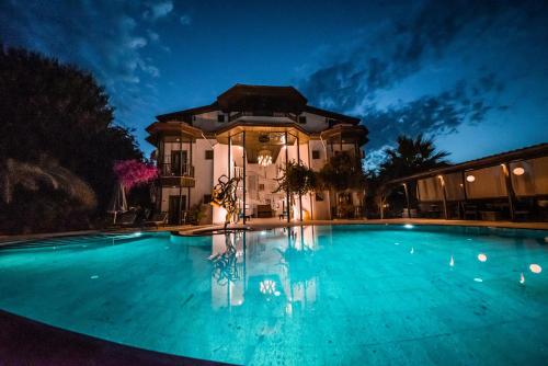 a large swimming pool in front of a house at Murat Pasha Mansion in Dalyan