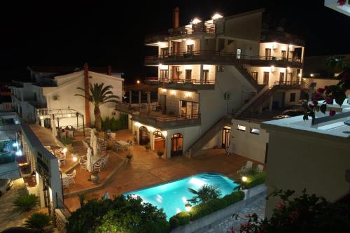 Blick auf ein Gebäude mit Schwimmbad bei Nacht in der Unterkunft H Kleopatra in Ulcinj