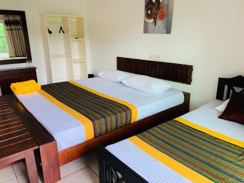 a bedroom with two beds and a piano at Sethway Village in Minneriya
