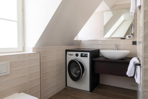 a bathroom with a washing machine and a sink at EMA House Serviced Apartments Superior Unterstrass in Zürich