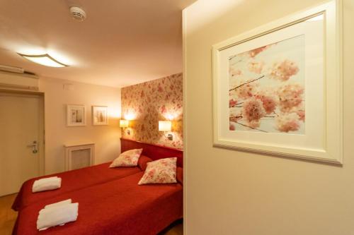Un dormitorio con una cama roja y una pintura en la pared en Hostal Matheu, en Madrid