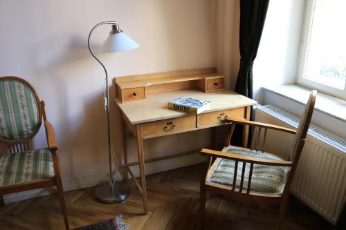 a desk with a lamp and two chairs in a room at Chopin Boutique in Warsaw